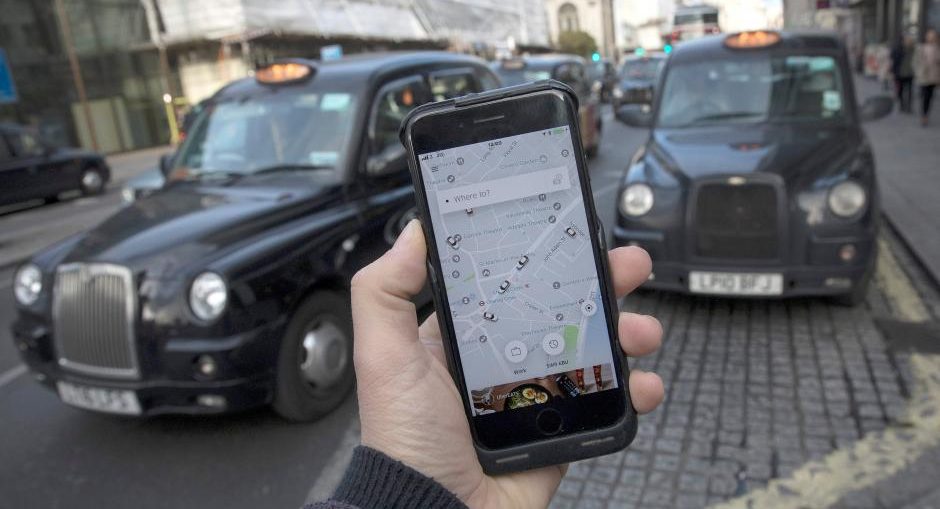 A photo illustration shows the Uber app on a mobile telephone, as it is held up for a posed photograph, with London Taxis in the background, in London, Britain November 10, 2017. REUTERS/Simon Dawson